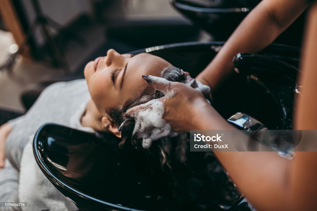 beautiful young woman getting a hair wash. hair salon styling concept.